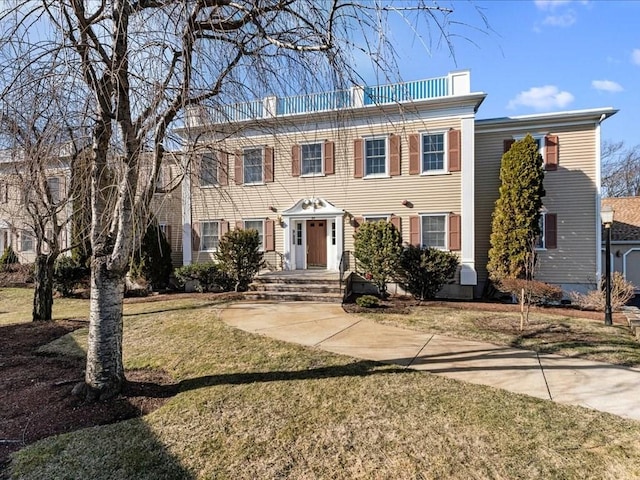 colonial house featuring a front lawn