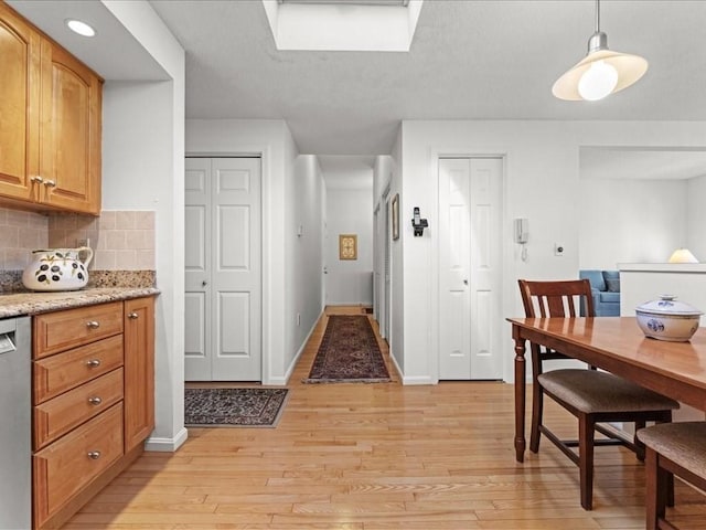 dining area with light wood-type flooring and baseboards