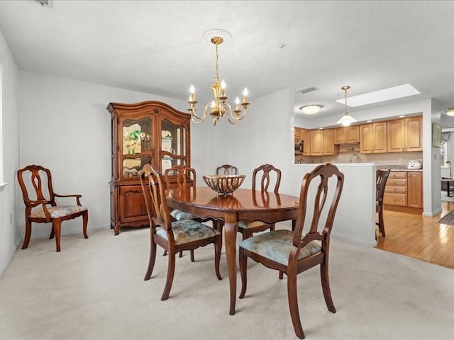 dining room with light carpet, a chandelier, baseboards, and visible vents