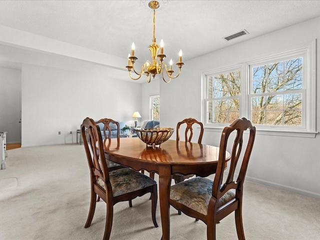 dining room featuring visible vents, baseboards, light carpet, a notable chandelier, and a textured ceiling