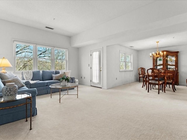 living room with a chandelier, visible vents, light colored carpet, and a textured ceiling