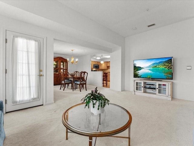 carpeted living area featuring visible vents and a chandelier