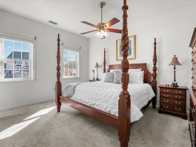 carpeted bedroom featuring baseboards, visible vents, and ceiling fan