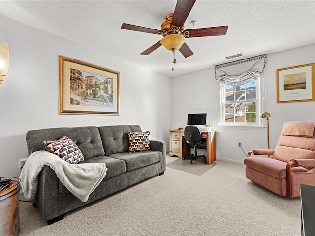 living area with visible vents, baseboards, carpet, a textured ceiling, and a ceiling fan