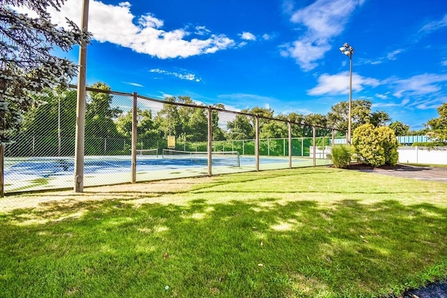 view of sport court featuring a lawn and fence