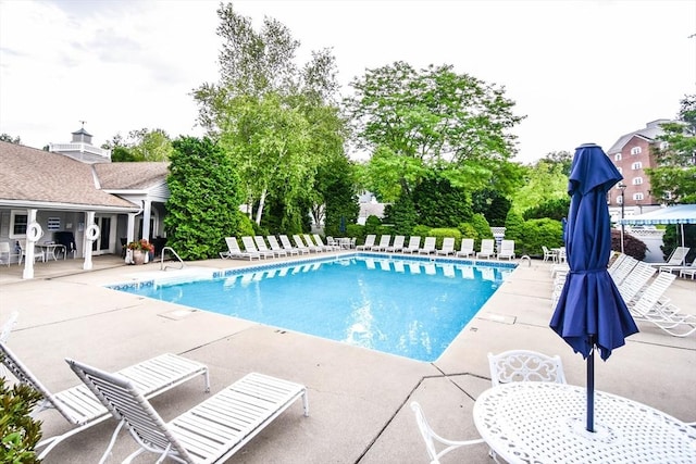 pool with outdoor dining area, fence, and a patio area