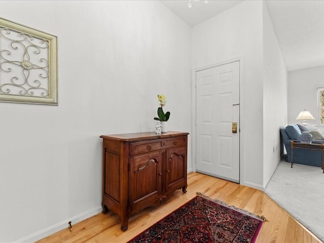 entrance foyer with baseboards and light wood finished floors