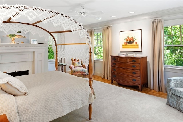 bedroom with ceiling fan, light hardwood / wood-style floors, and ornamental molding