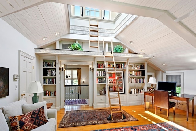 living room with wood ceiling, a healthy amount of sunlight, light wood-type flooring, and lofted ceiling with skylight