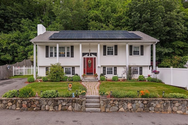 14 W Winkley St, Amesbury, MA 01913 - split foyer home with a chimney, roof mounted solar panels, and a porch