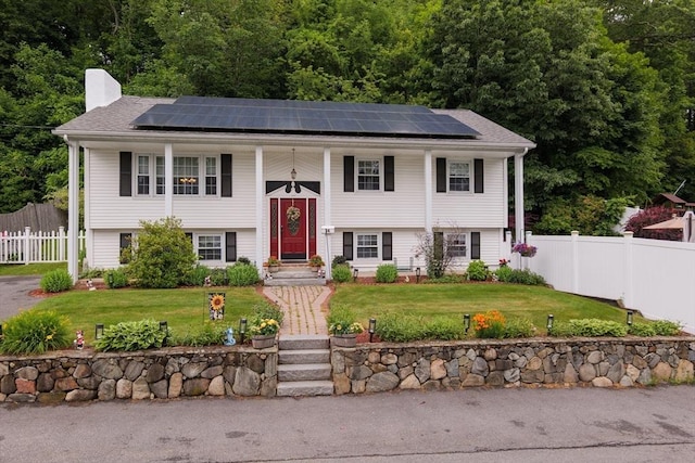 14 W Winkley St, Amesbury, MA 01913 - split foyer home featuring a chimney, roof mounted solar panels, and covered porch
