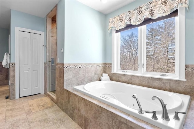 full bathroom with tile patterned floors, plenty of natural light, a garden tub, and a shower stall