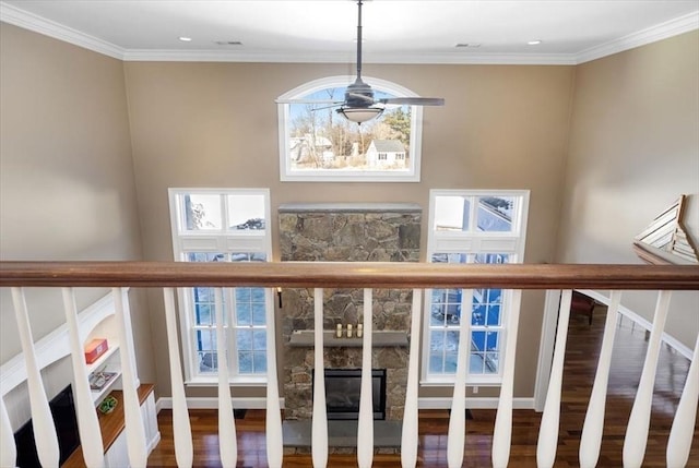 interior details with a glass covered fireplace, crown molding, baseboards, and wood finished floors