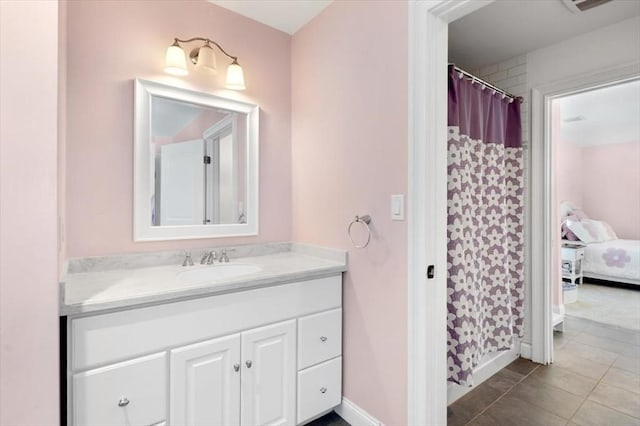 ensuite bathroom featuring ensuite bathroom, vanity, a shower with curtain, baseboards, and tile patterned floors