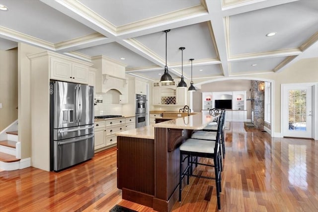 kitchen with stainless steel appliances, a breakfast bar, coffered ceiling, dark wood-style floors, and tasteful backsplash