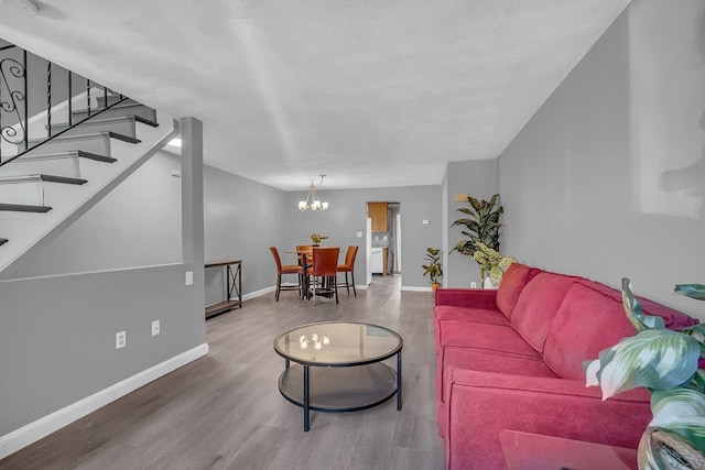 living room featuring hardwood / wood-style floors, a textured ceiling, and an inviting chandelier