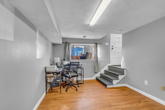 office area featuring a textured ceiling and light hardwood / wood-style floors