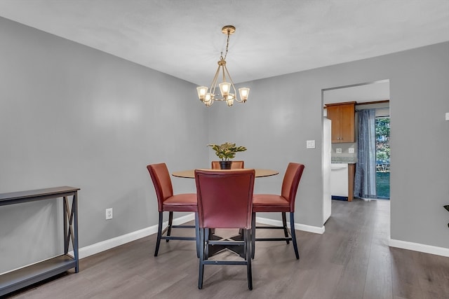 dining space featuring hardwood / wood-style flooring and an inviting chandelier