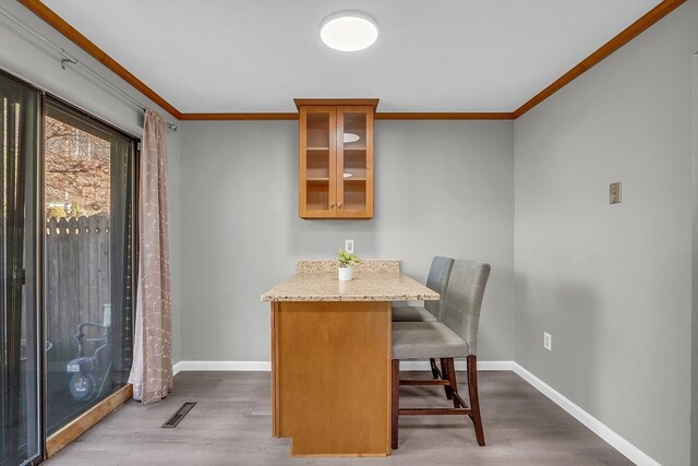 dining space with hardwood / wood-style flooring and crown molding