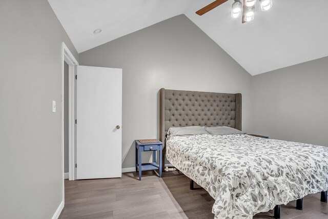 bedroom with ceiling fan, light hardwood / wood-style flooring, and high vaulted ceiling