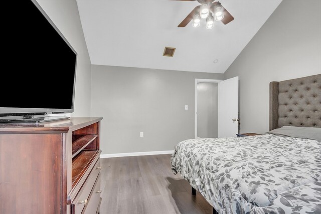 bedroom featuring light wood-type flooring, vaulted ceiling, and ceiling fan