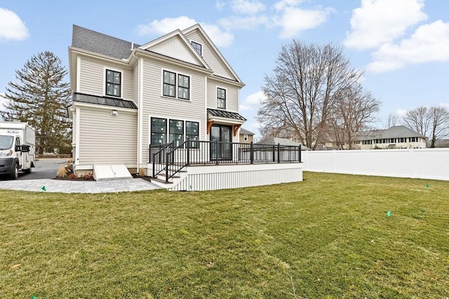 back of house with a wooden deck and a lawn