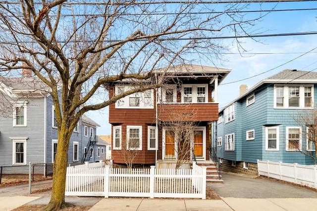 view of front facade with a fenced front yard and a balcony