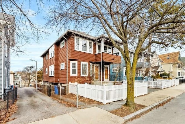 view of front of home with a balcony and a fenced front yard