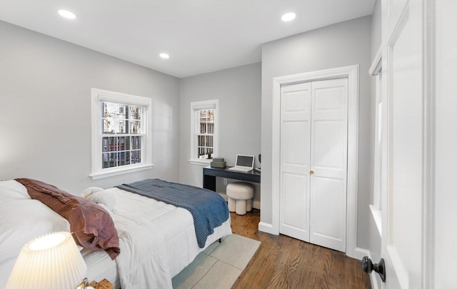 bedroom featuring a closet, baseboards, dark wood-style flooring, and recessed lighting