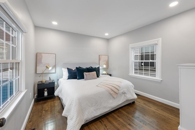 bedroom featuring multiple windows, dark wood-style flooring, and baseboards