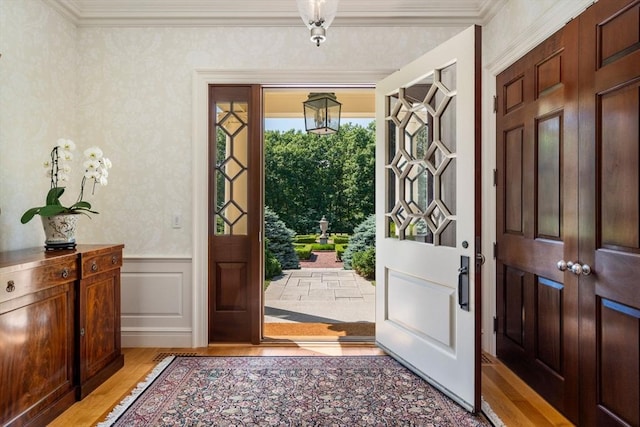495 Hugh Cargill Rd, Concord, MA 01742 - entryway with light wood-style floors, a wainscoted wall, ornamental molding, and a decorative wall