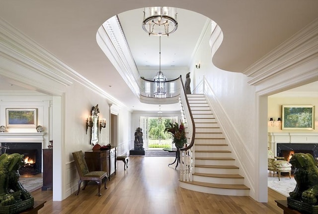 495 Hugh Cargill Rd, Concord, MA 01742 - foyer entrance with a lit fireplace, ornamental molding, and an inviting chandelier