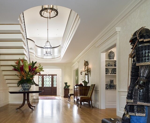 495 Hugh Cargill Rd, Concord, MA 01742 - entrance foyer with an inviting chandelier, arched walkways, a decorative wall, and wood finished floors