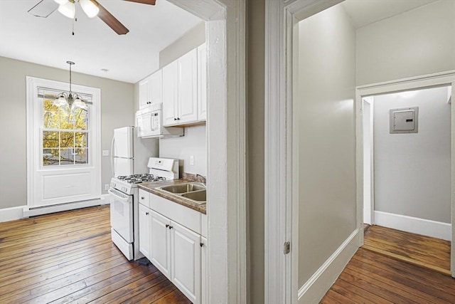 kitchen with white cabinetry, sink, baseboard heating, dark wood-type flooring, and white appliances