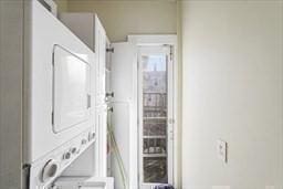 washroom featuring stacked washer and clothes dryer