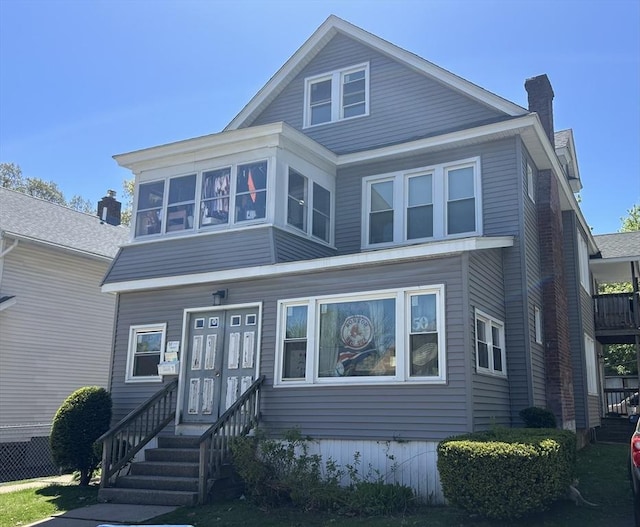 american foursquare style home with a chimney