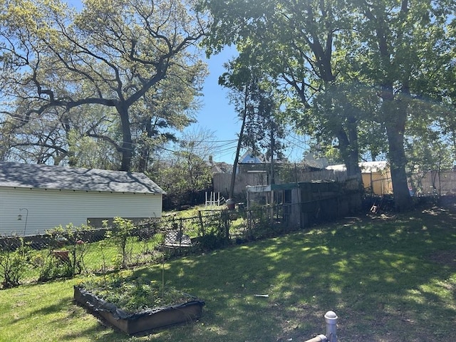 view of yard featuring fence and a garden
