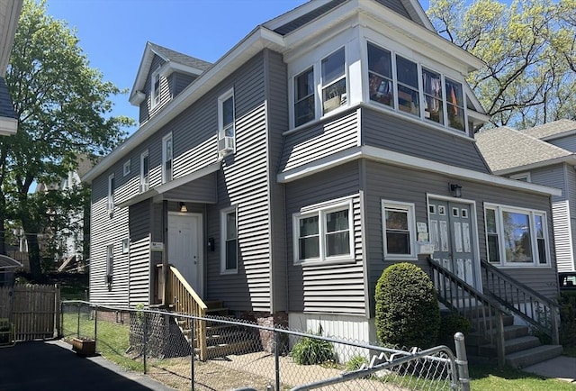 view of front of property with entry steps, a gate, and a fenced front yard