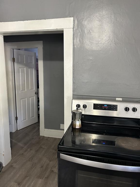details with stainless steel electric range oven, dark wood-style flooring, and baseboards