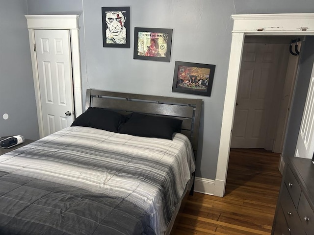 bedroom with baseboards and dark wood finished floors