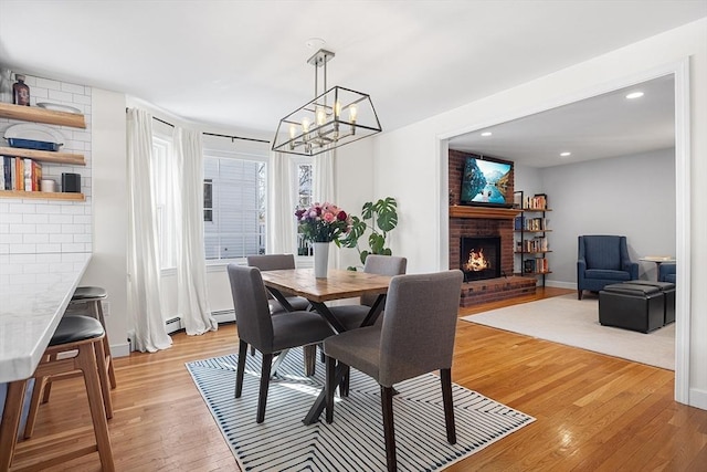 dining room featuring recessed lighting, a brick fireplace, light wood-style flooring, and baseboard heating