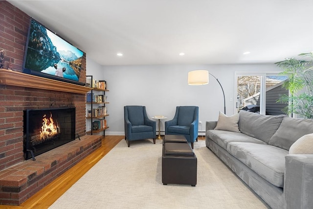 living room with recessed lighting, a baseboard heating unit, a fireplace, wood finished floors, and baseboards