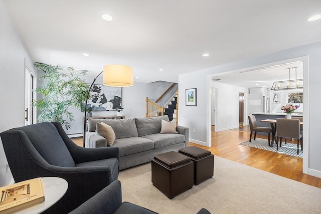 living room with baseboards, stairway, recessed lighting, and light wood-style floors