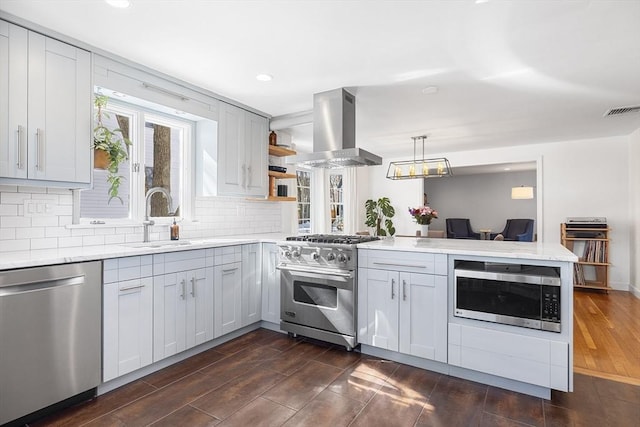 kitchen with island exhaust hood, open shelves, visible vents, appliances with stainless steel finishes, and a peninsula