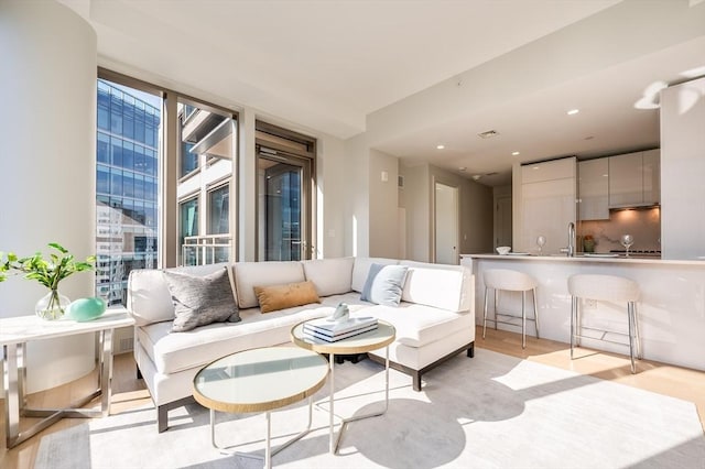 living room featuring light wood-style floors and visible vents