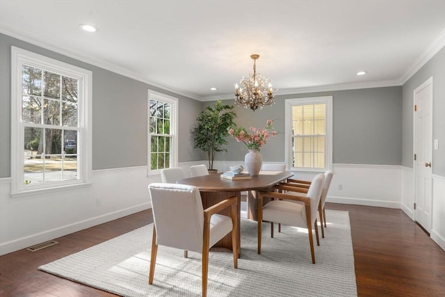 dining room featuring visible vents, wainscoting, ornamental molding, and wood finished floors