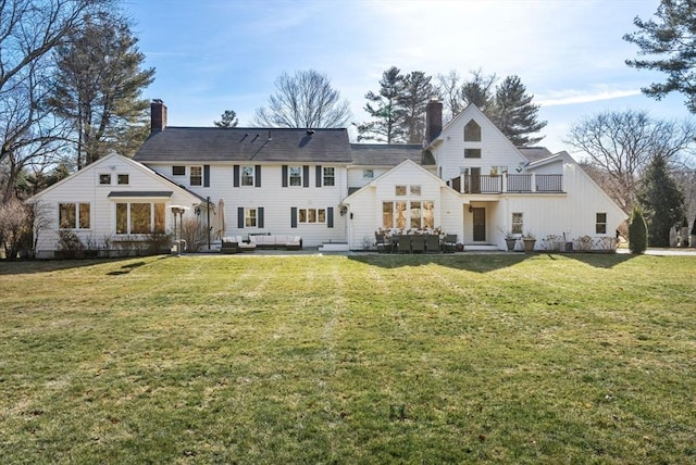 rear view of property with a patio area, an outdoor hangout area, a chimney, and a yard