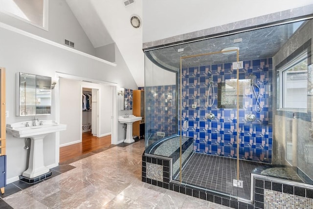 bathroom with visible vents, a shower stall, baseboards, and vaulted ceiling