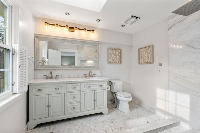 bathroom with a sink, visible vents, toilet, and double vanity