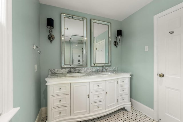 bathroom featuring double vanity, baseboards, and a sink